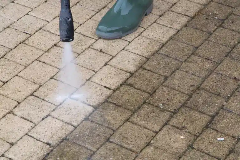 A person pressure washing a driveway